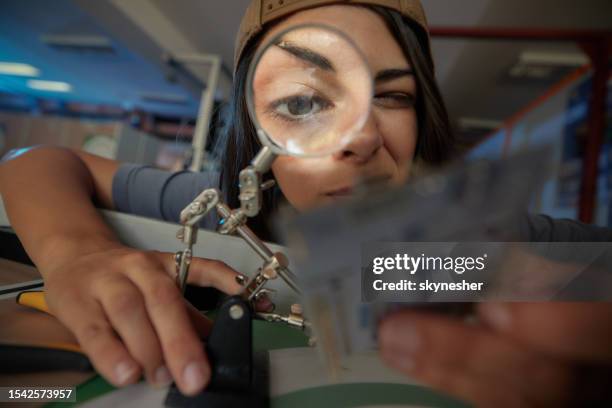 esaminare il chip del computer con la lente d'ingrandimento! - lente dingrandimento foto e immagini stock