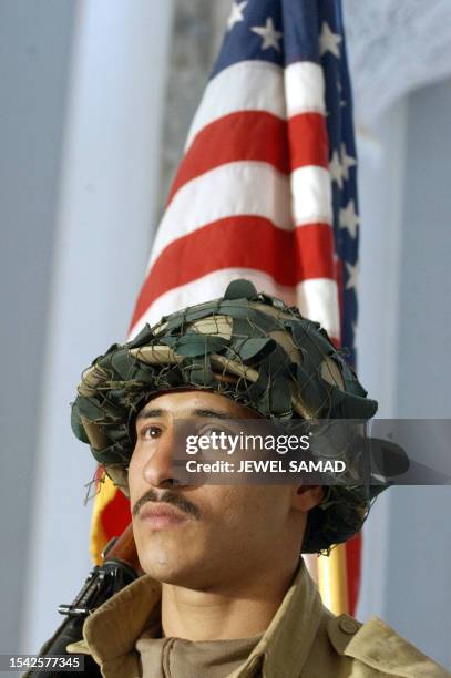 An Iraq Civil Defence Corps soldier marches before a US national flag during a graduation ceremony of ICDC soldiers trained by the 4th Infantry...