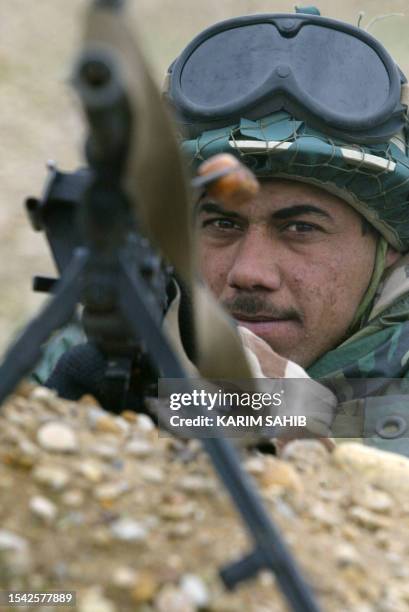 Soldier from the new Iraqi army's 1st Batallion takes aim with a machine gun during training in Mandali, 110km northeast of Baghdad near the Iranian...