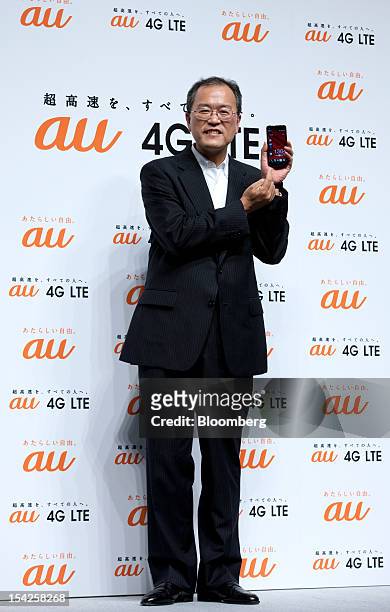 Takashi Tanaka, president of KDDI Corp., poses with the HTC J smartphone during the unveiling of the company's new smartphone line-up in Tokyo,...