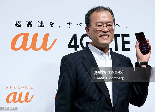 Takashi Tanaka, president of KDDI Corp., poses with the HTC J smartphone during the unveiling of the company's new smartphone line-up in Tokyo,...