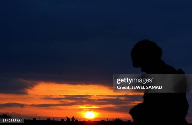 Soldier from the 4th Infantry Division poses at sunset on Christmas eve in Tikrit, 180 Kilometers north of Iraqi capital Baghdad, 24 December 2003....