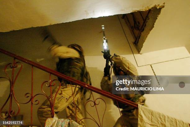 Soldiers inspect a house during a raid in the area on the outskirts of Tikrit, 180 kms north of Iraq's capital Baghdad, early 11 December 2003. US...