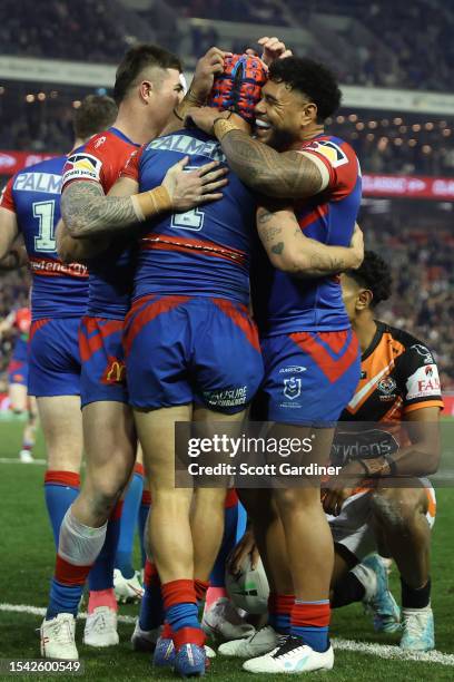 Knight players celebrate the try of Kalyn Ponga during the round 20 NRL match between Newcastle Knights and Wests Tigers at McDonald Jones Stadium on...