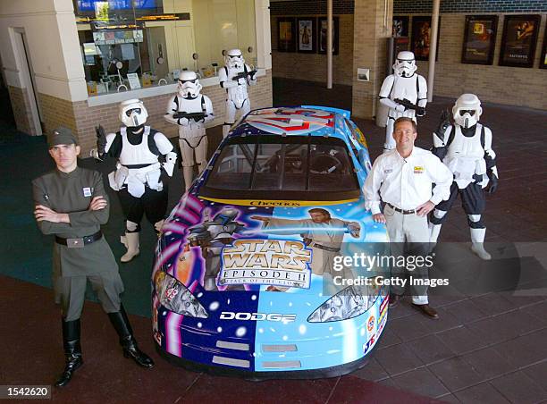 Star Wars fans, dressed as stormtrooper characters, stand next to the Star Wars-schemed Cheerios No. 43 Dodge Intrepid car commemorating the release...