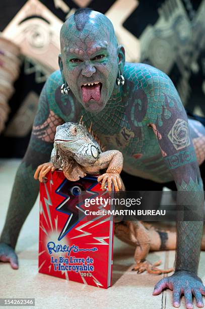 Erik Sprague, also known as "The Lizardman", poses with an iguana during the launching of the book "Le Big Livre de l'Incroyable" , on October 17,...