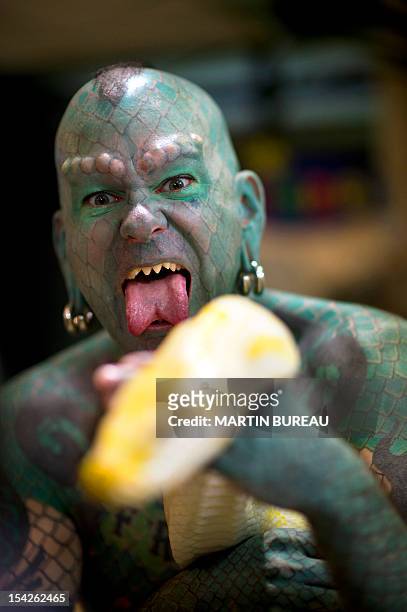 Erik Sprague, also known as "The Lizardman", poses with a snake during the launching of the book "Le Big Livre de l'Incroyable" , on October 17, 2012...