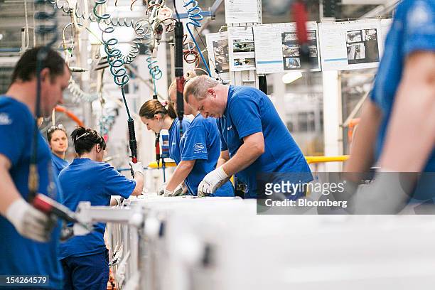 Employees work on the assembly of domestic washing machines on the production line at the Electrolux AB plant in Olawa, Poland, on Tuesday, Oct. 16,...
