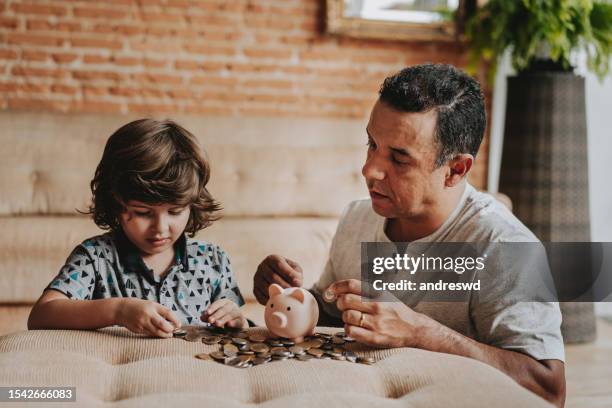 father and son coin bank - boys money stock pictures, royalty-free photos & images