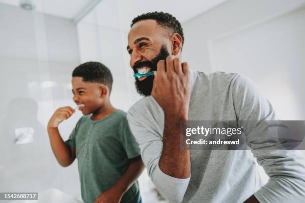 father teaching son to brush teeth - dental bonding stock pictures, royalty-free photos & images