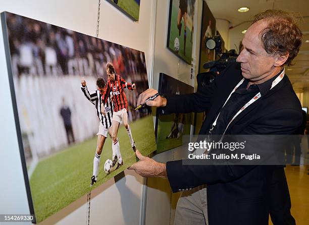 Former football player Franco Baresi signs exhibition's pictures during a visit to the Golden Foot 2012 photo exhibition at Grimaldi Forum on October...
