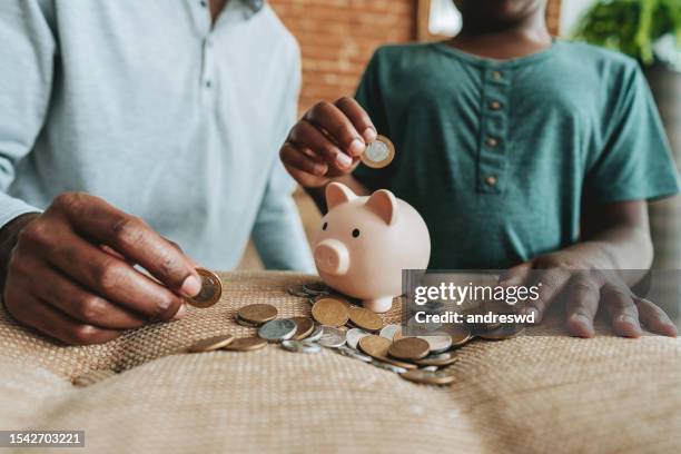 father and son coin bank - economics lesson stock pictures, royalty-free photos & images