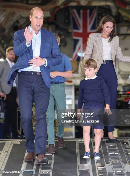 Prince William, Prince of Wales and Catherine, Princess of Wales with Prince Louis of Wales as they walk down the ramp of a C17 plane during their...