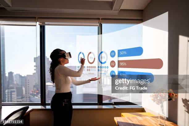 junge frau, die mit virtual-reality-simulator im büro arbeitet - erweiterte realität stock-fotos und bilder
