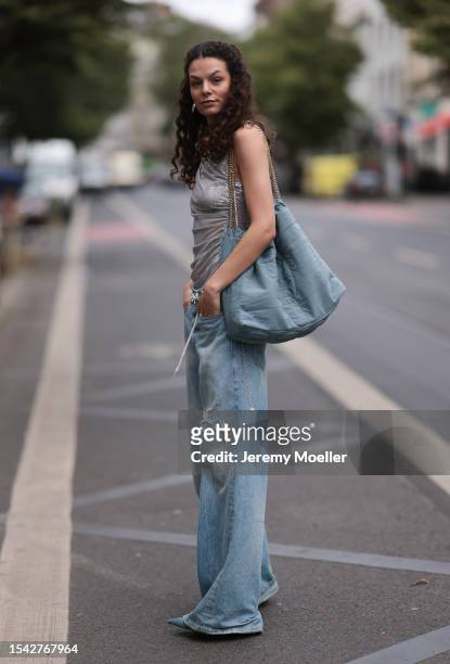 Joelle Juana wearing grey ruffled top with silver applications, denim Ariane Ernst bag, baggy, blue, oversized and distressed pair of jeans, silver,...
