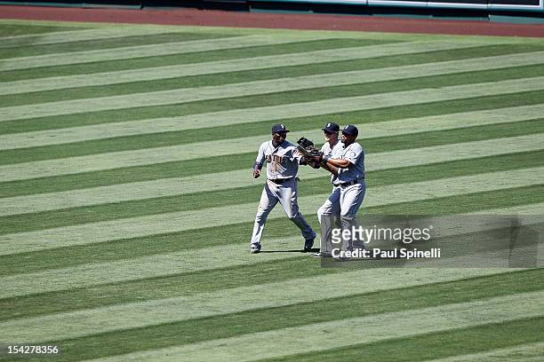 Trayvon Robinson, Michael Saunders, and Eric Thames of the Seattle Mariners celebrate after defeating the Los Angeles Angels of Anaheim on August 12,...