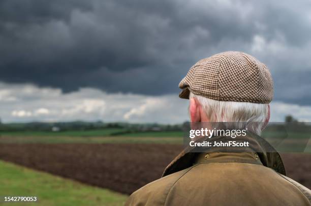 senior farmer looking at a ploughed field - waxed jacket stock pictures, royalty-free photos & images