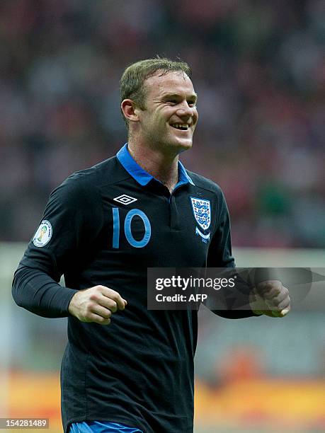 England's Wayne Rooney celebrates after scoring during the FIFA 2014 World Cup qualifying football match Poland vs England in Warsaw on October 17,...