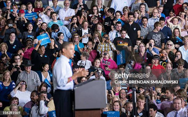 People listen as US President Barack Obama speaks during a rally at Cornell College October 17, 2012 in Mt. Vernon, Iowa. Obama is traveling to Iowa...