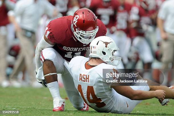 Defensive end R.J. Washington of the Oklahoma Sooners talks with quarterback David Ash of the Texas Longhorns after knocking him down on October 13,...