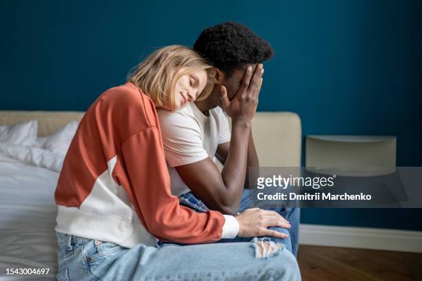 young loving supportive woman comforting upset crying husband at home - boyfriend crying stock-fotos und bilder