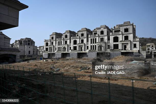 This photo taken on March 31, 2023 shows deserted villas in a suburb of Shenyang in China's northeastern Liaoning province. Cattle wander between the...