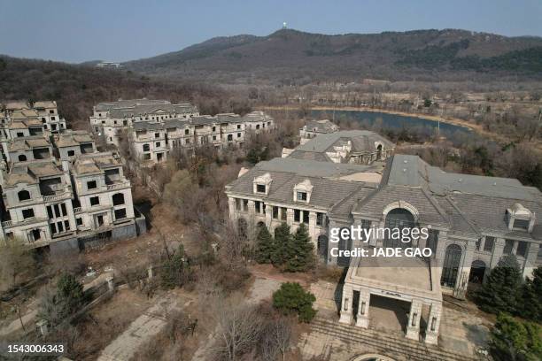 This aerial photo taken on March 31, 2023 shows deserted villas in a suburb of Shenyang in China's northeastern Liaoning province. Cattle wander...