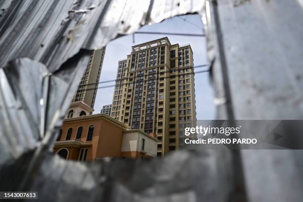 This photo taken on June 20, 2023 shows a view of a complex of unfinished apartment buildings in Xinzheng City in Zhengzhou, China's central Henan...