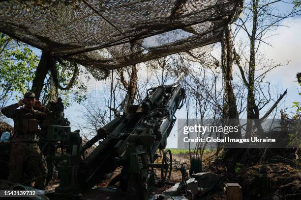 Gun crew of the M777 howitzer aims artillery fire onto Russian positions near the occupied Ukrainian city of Bakhmut on July 13, 2023 in Donetsk...