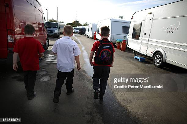Children walk along a line of caravans on an access road to Dale Farm travellers site on October 17, 2012 near Basildon, England. A year after local...