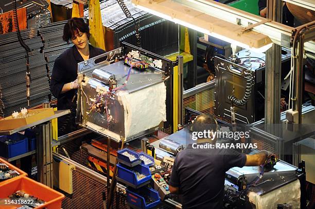 People work on an assembly line at the Mondragon group's Fagor electrical appliances' plant on October 5 in the Northern Spanish Basque town of...