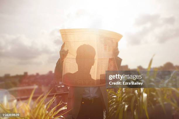 silhouette of a businessman reading the paper. - zeitung im broadsheet format stock-fotos und bilder