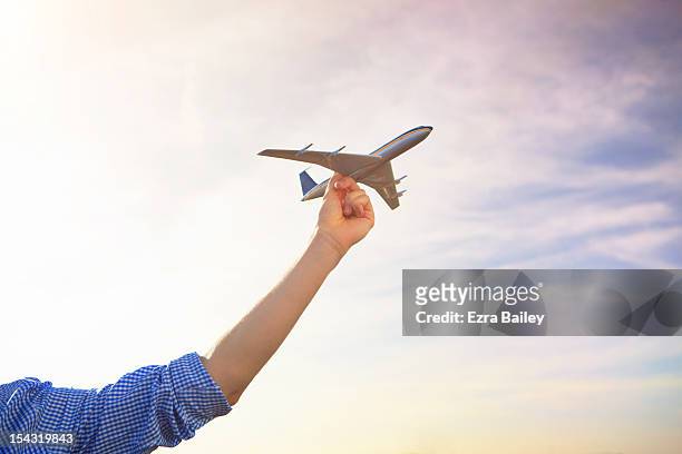 man holding a model plane to the sky. - toy airplane stock-fotos und bilder