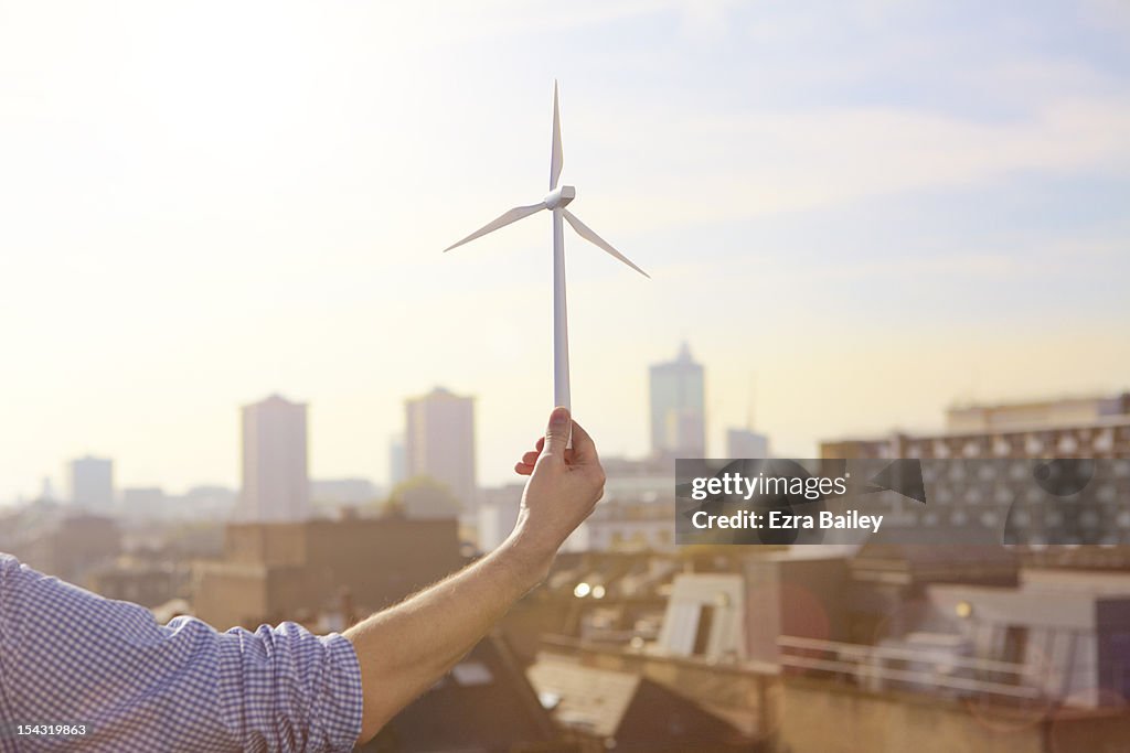 Man holding a model wind turbine.