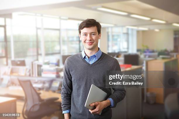 a young businessman in open plan office - holding digital tablet stock pictures, royalty-free photos & images