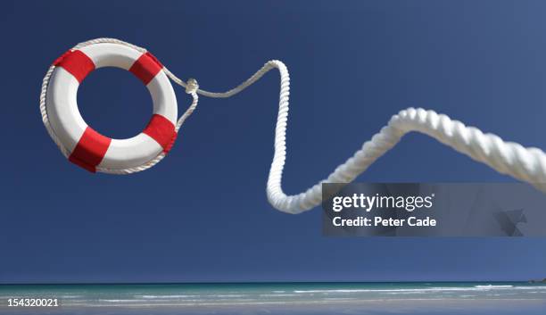 lifering in air on beach - salvagente foto e immagini stock