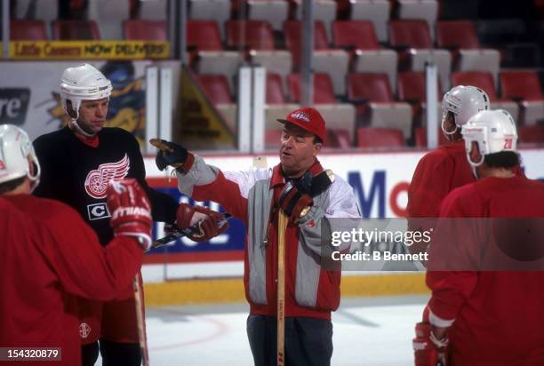 Head coach Scotty Bowman of the Detroit Red Wings talks to his players, including Viacheslav Fetisov during practice before a 1995 Stanley Cup game...