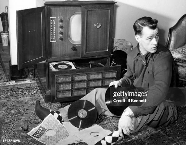 Gordie Howe of the Detroit Red Wings listens to his record collection while at home as he is the roommate of teammate Ted Lindsay on February 16,...