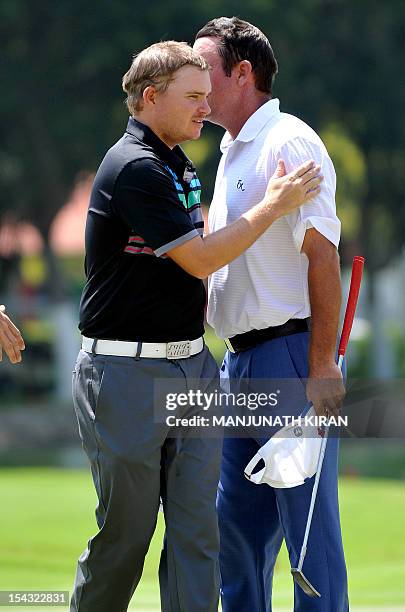 England golfer, James Morrison greets Australian golfer Scott Hend during the first round of the Hero Indian Open 2012 Golf Tournament held at the...