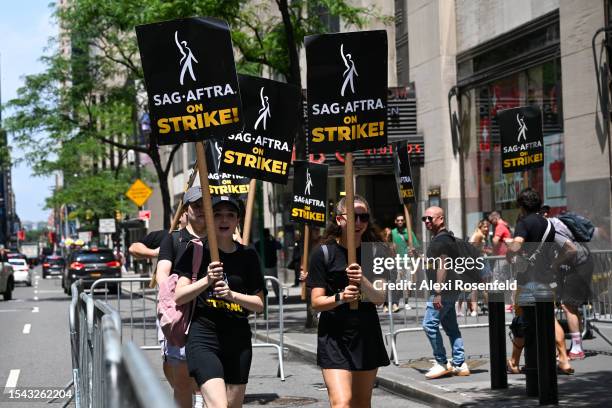 Members of the Writers Guild of America East and SAG-AFTRA walk the picket line on Day 2 outside NBC Rockefeller Center on July 14, 2023 in New York...