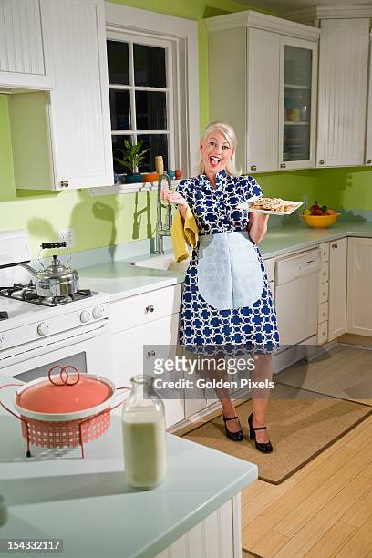 retro housewife in kitchen with cookies - 1950 females only housewife stockfoto's en -beelden
