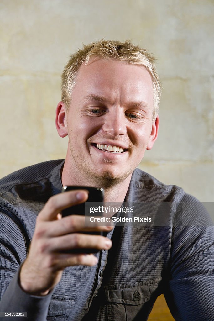 Man holding mobile phone, texting