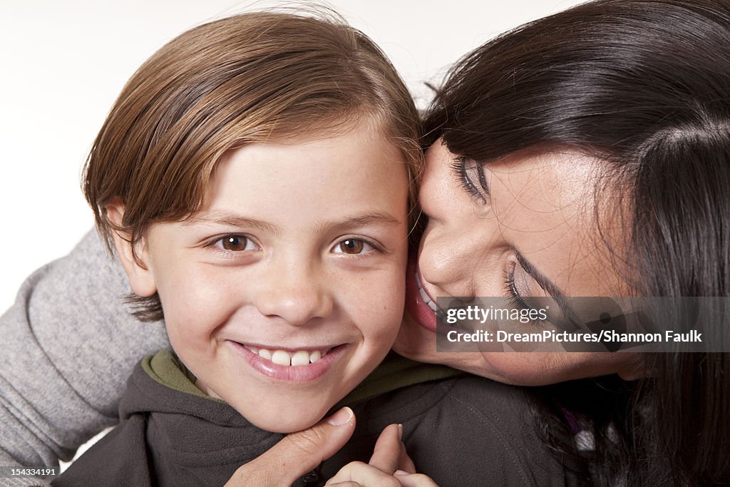Studio portrait of smiling woman with son (8-9)