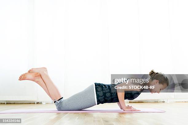 teenage girl doing gymnastics - knielen stockfoto's en -beelden