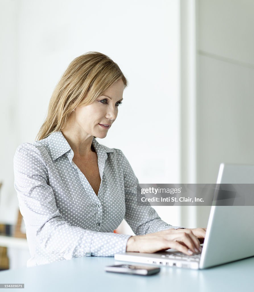 Businesswoman using a laptop at home