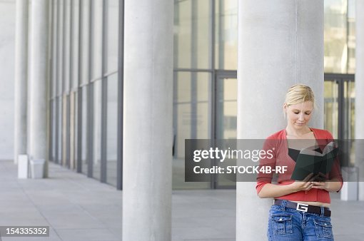 Column Reading Young Woman Leaning Against Column Reading Book Stock-Foto - Getty Images