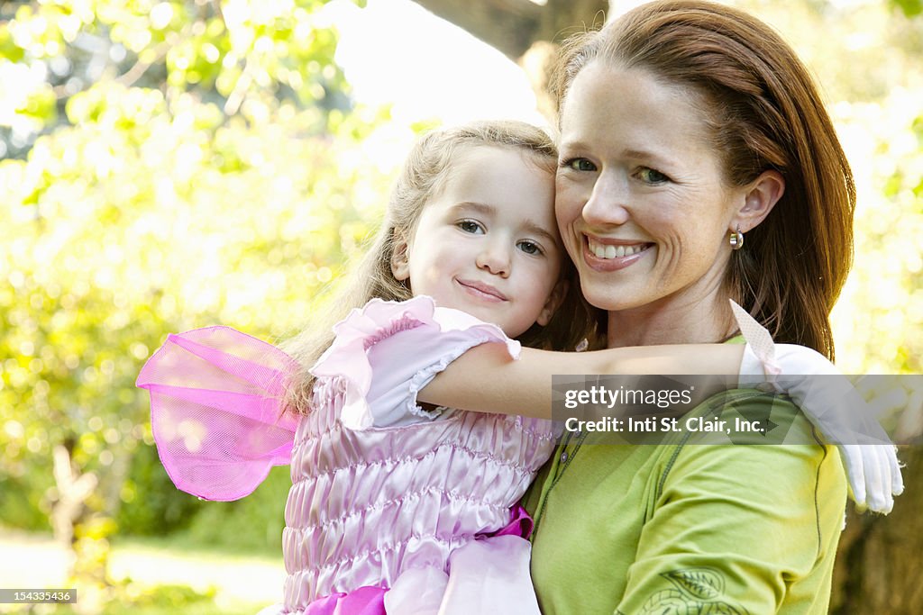 Mother and daughter (4-5) hugging and smiling