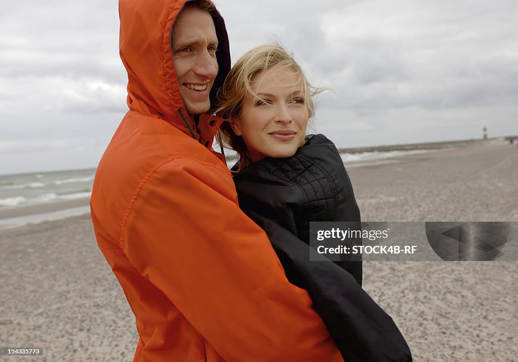 Couple on the beach under cloudy sky