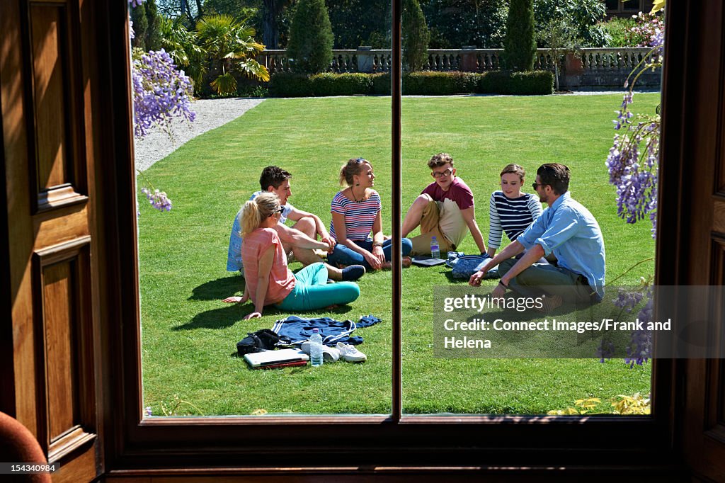 Friends relaxing on manicured lawn