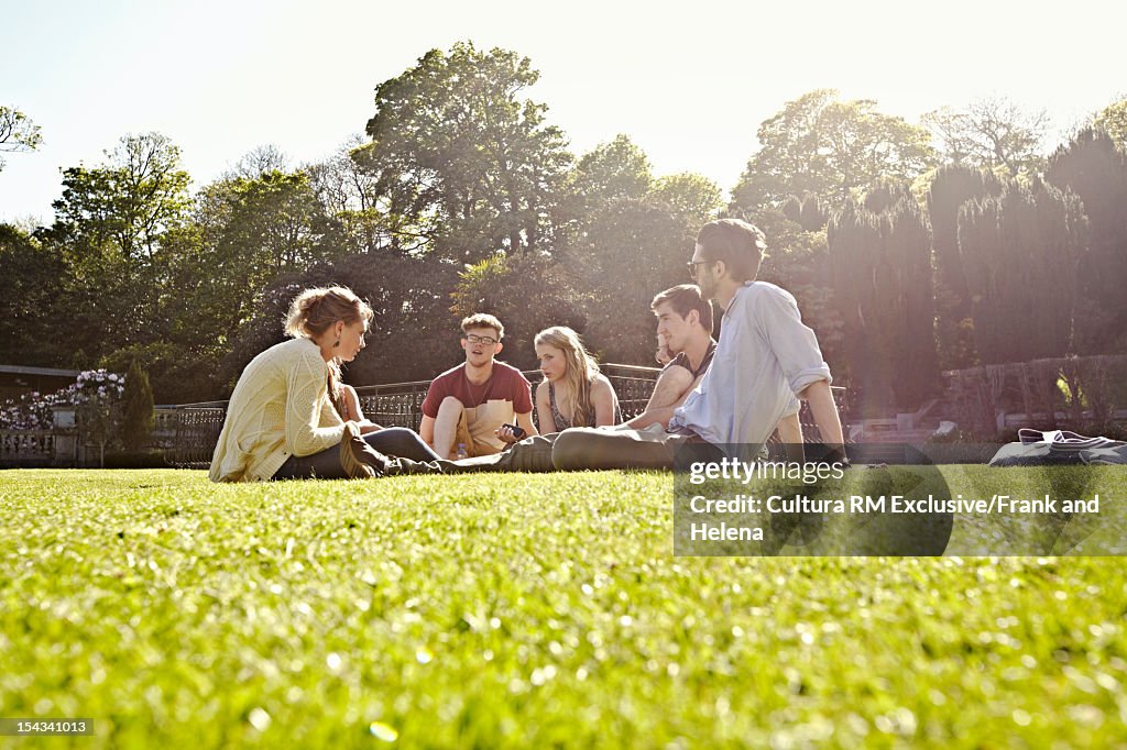 Friends relaxing on manicured lawn